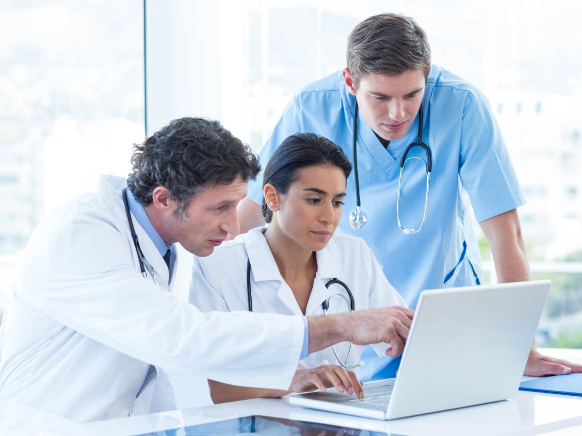 Primena ChatGPT veštačke inteligencije u medicini - lekari gledaju u ekran laptopa