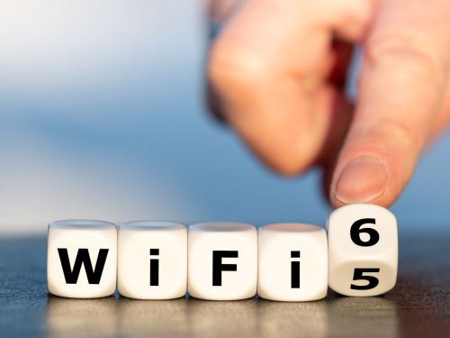 Čovek prstom okreće Wi-Fi 5 i Wi-Fi 6 kockice
