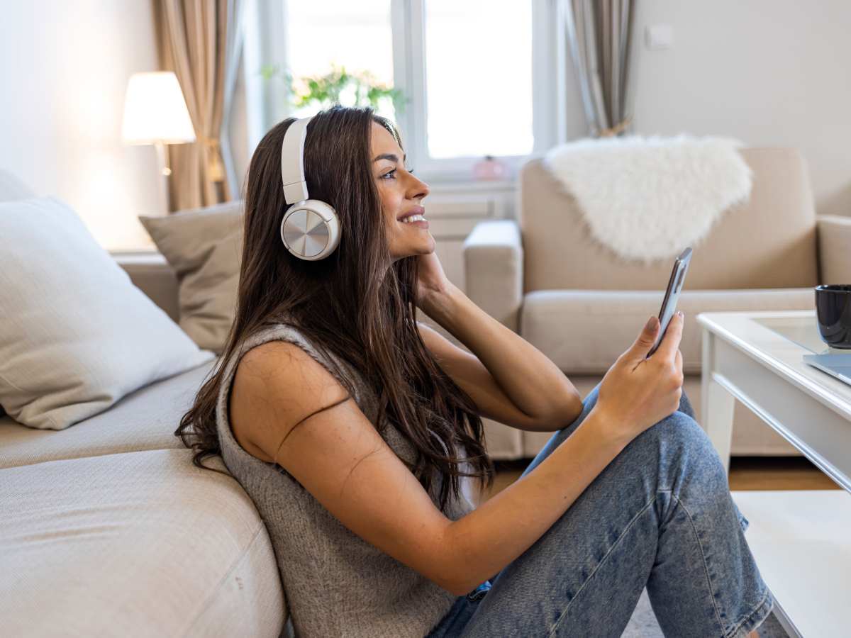 Devojka koristi Bluetooth slušalice i mobilni telefon