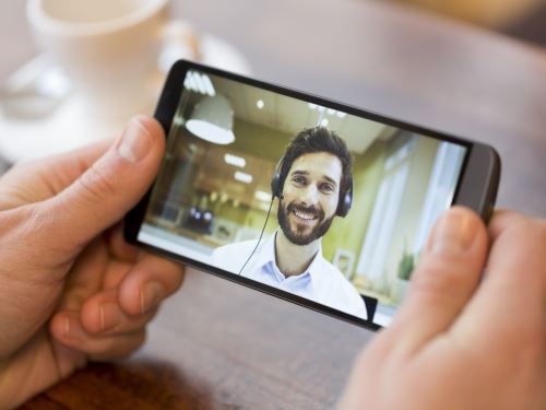 Kako instalirati Skype na mobilni telefon - Osoba drži telefon i obavlja video-poziv